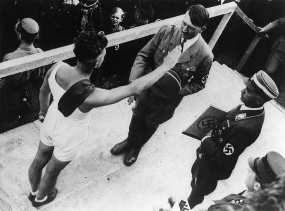 During a rally for the connection and loyalty of the Saarland to the German Reich on the fortress Ehrenbreitstein near Koblenz, Adolf Hitler salutes one of the 170,000 attending athletes